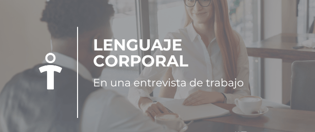 Dos personas en una entrevista de trabajo conversan en una mesa, destacando el lenguaje corporal.
