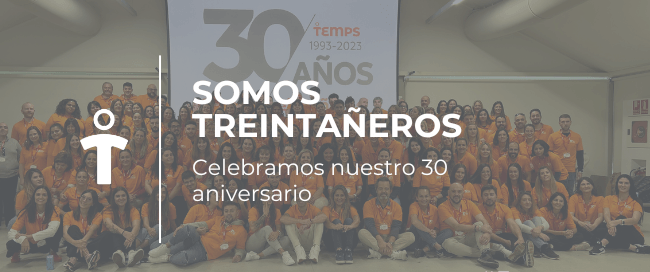 Group photo of employees in orange shirts celebrating the company's 30th anniversary, with a banner reading '30 Años' in the background.