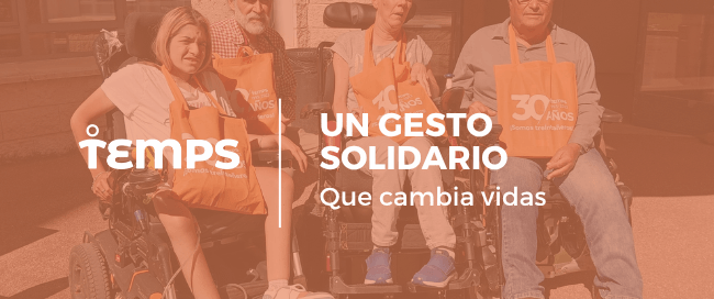 Grupo de personas en sillas de ruedas y voluntarios con mandiles naranjas posando para una campaña solidaria, con el texto 'Un gesto solidario que cambia vidas'